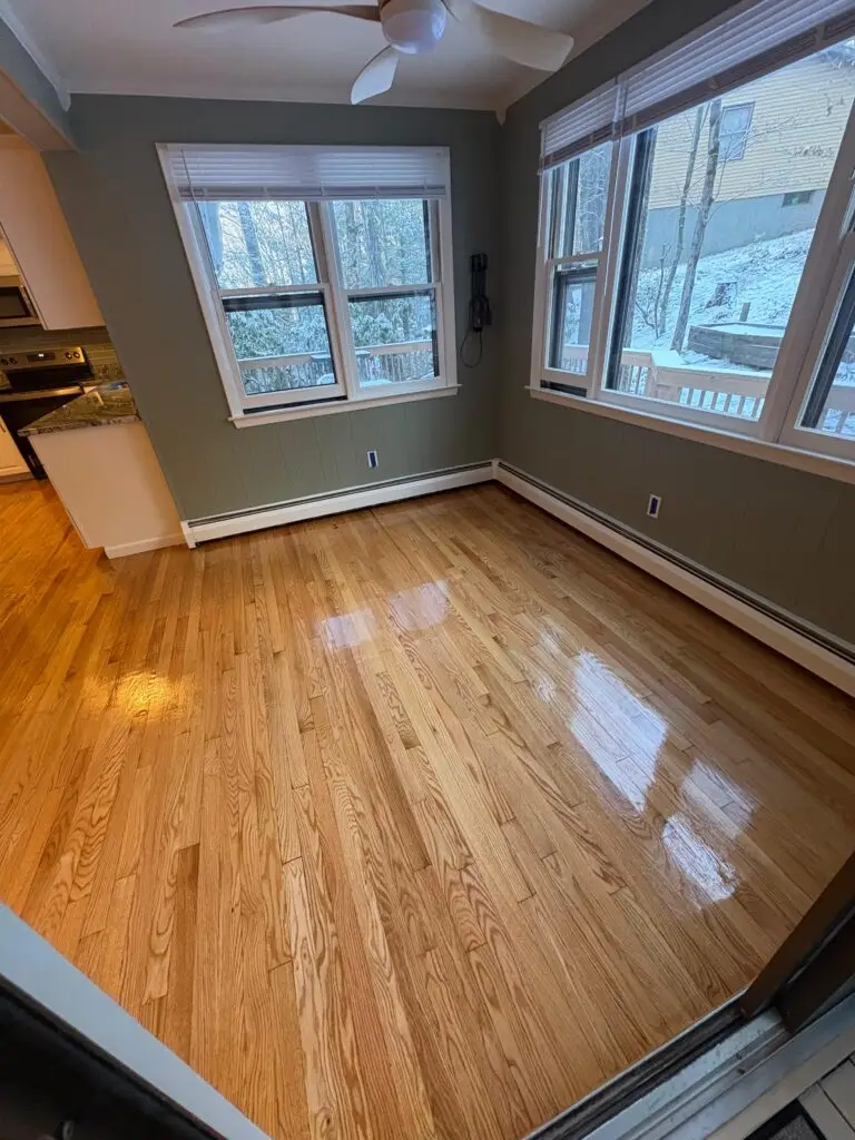 Bright, empty room with hardwood floor.