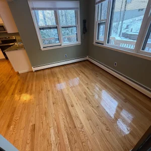 Bright, empty room with hardwood floor.